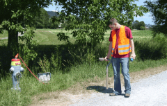 Ein Arbeiter ortet eine Leitung am Strassenrand